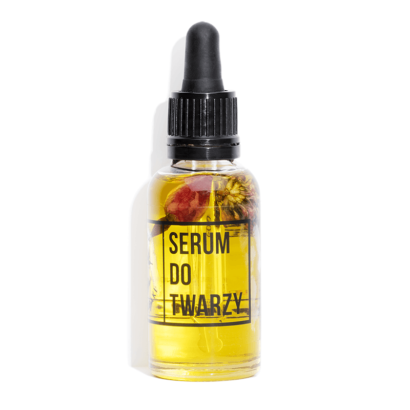 Żółte serum w przezroczystej butelce z czarnym kroplomierzem-pipetką. W środku są zatopione kwiaty